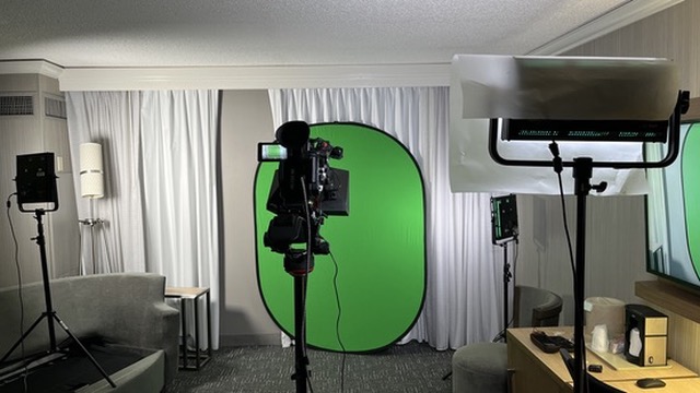 Setting up a green screen interview in a hotel room.